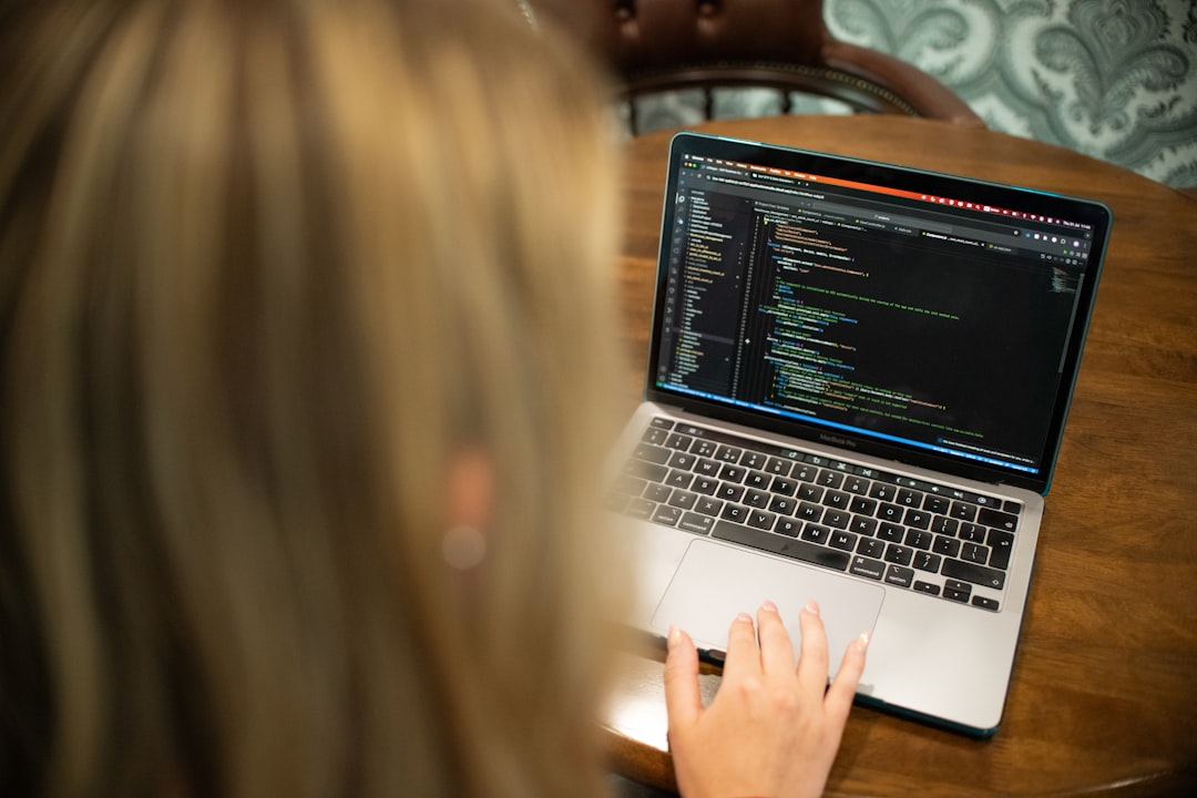 Woman typing code on a laptop computer.