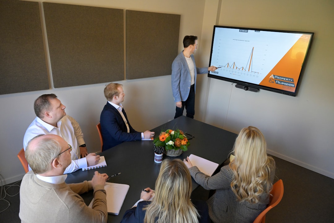 A man presents a graph to colleagues in a meeting.