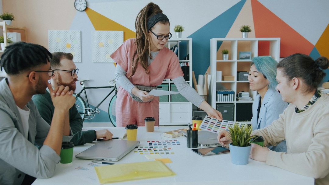 A woman with dreadlocks showing a color palette to colleagues in a creative office