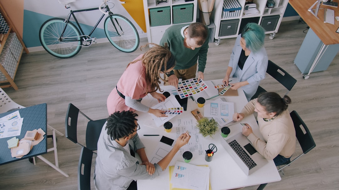 A group of people collaborating on design projects at a table in a workspace