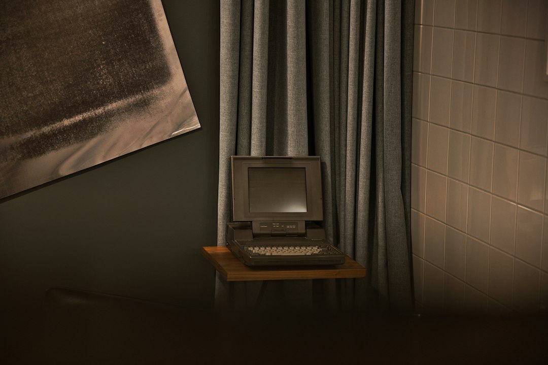 Vintage computer on a shelf with curtains